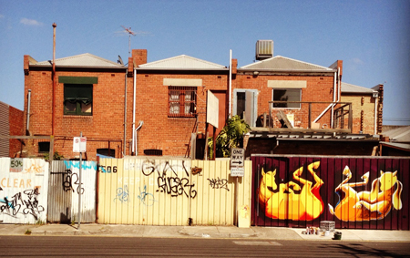 The Melbourne Food Depot rear gates being painted by Kaffeine, melbourne street artist